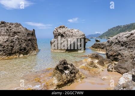 Rocce sulla spiaggia vicino Agios Gordios città su un'isola greca di Corfù Foto Stock