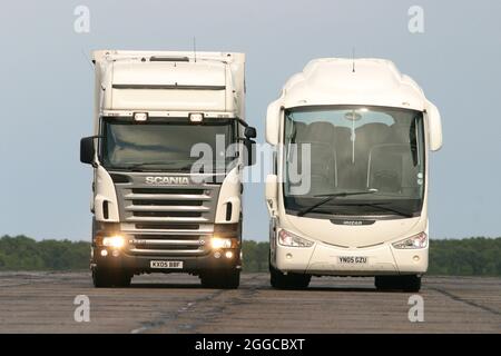 Camion HGV passando un pullman su una pista di prova umida Foto Stock