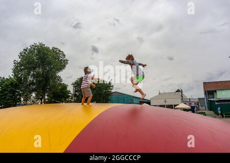 KOSCIAN, POLONIA - 01 ago 2021: I ragazzi maschi su un cuscino colorato nel parco ricreativo Nenufar Club di Koschian, Polonia Foto Stock