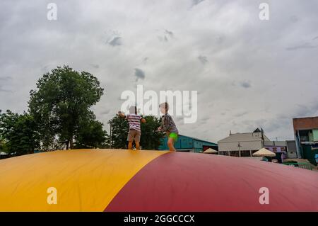 KOSCIAN, POLONIA - 01 ago 2021: I ragazzi maschi su un cuscino colorato nel parco ricreativo Nenufar Club di Koschian, Polonia Foto Stock