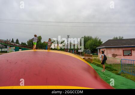 KOSCIAN, POLONIA - 01 ago 2021: I ragazzi maschi su un cuscino colorato nel parco ricreativo Nenufar Club di Koschian, Polonia Foto Stock