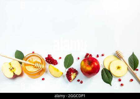 Concetto di tradizionale vacanza ebraica di Rosh Hashanah. Anno nuovo. Melagrane, miele e mele su sfondo bianco. Inserire il testo. Foto Stock