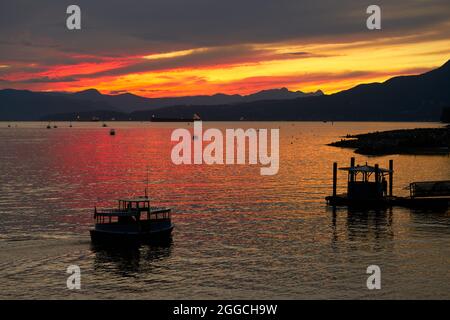 False Creek Ferry Sunset Vancouver. Tramonto sulla English Bay. Un traghetto per pendolari si dirige verso il molo. Vancouver, British Columbia, Canada. Foto Stock