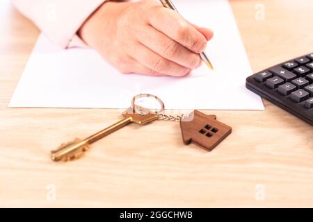 firmando un contratto d'affitto, l'agente immobiliare firma un contratto d'affitto Foto Stock