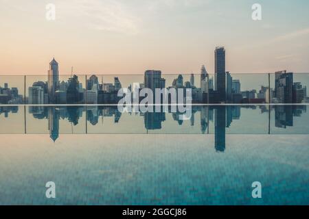 Paesaggi urbani e alti edifici nella città metropoli con riflessi d'acqua al mattino presto.