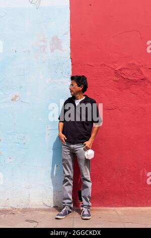 uomo ispanico in piedi di fronte al muro colorato ad antigua guatemala Foto Stock