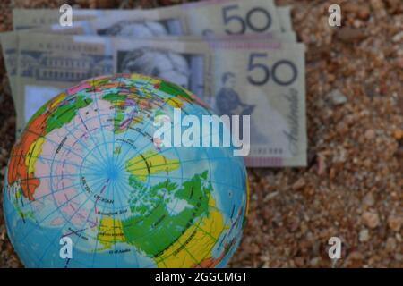 Mappa del globo terrestre dell'Artico, seduta su un gruppo di banconote in natura. Foto Stock