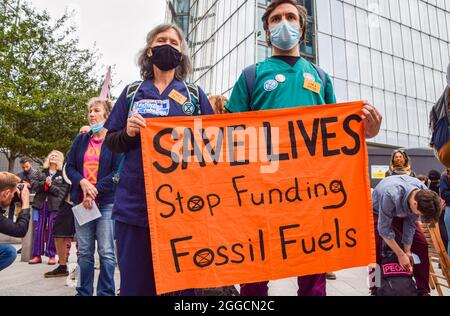 Londra, Regno Unito. 30 ago 2021. I manifestanti hanno un banner che dice "Salva vite, Stop Funding Fossil Fuels" durante la manifestazione al di fuori di News UK. I manifestanti di estinzione della ribellione marciarono da Rupert Murdoch's News UK a Tower Bridge come parte della loro campagna di ribellione impossibile di due settimane, chiedendo al governo britannico di agire in modo significativo sulla crisi climatica ed ecologica. Credit: SOPA Images Limited/Alamy Live News Foto Stock