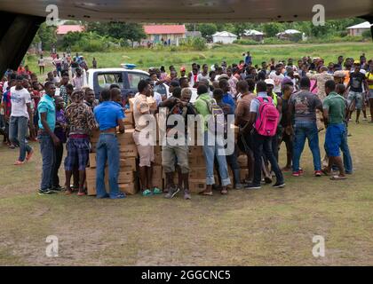 Port Au Prince, Haiti. 27 ago 2021. I marines degli Stati Uniti ed i volontari hanno scaricato le forniture di cibo da un elicottero CH-47 Chinook durante una missione umanitaria 27 agosto 2021 vicino Port-au-Prince, Haiti. I militari, l'USAID e i volontari stanno assistendo nel periodo successivo al recente terremoto. Credit: Planetpix/Alamy Live News Foto Stock