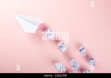 Messaggio documento lettera piano carta. Vista dall'alto: Modello di viaggio in aereo, formazione o innovazione origami aereo, isolato su sfondo rosa wi Foto Stock