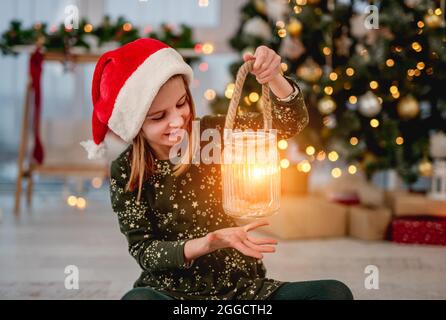 Bambina in santa cappello che tiene la candela Foto Stock