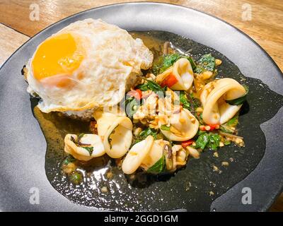Riso condito con calamari fritti e basilico con uova fritte Foto Stock