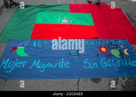 Barcellona, Catalogna, Spagna. 30 ago 2021. Bandiera del Consiglio regionale indigeno di Cauca è visto accanto ad una bandiera che legge, Ley de Extrajeria = donna migrante senza garanzie.circa 200 persone hanno dimostrato di fronte all'Arc de Triomf di Barcellona contro le 6402 uccisioni extragiudiziali commesse dall'esercito nel contesto del conflitto armato colombiano, un fenomeno noto come ''falsi positivi''. La manifestazione si è svolta in occasione della Giornata Internazionale delle vittime della sparizione forzata, commemorata ogni 30 agosto e alla quale ha partecipato Ricardo ''Profe' Foto Stock