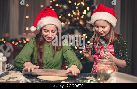 Buone amiche preparare pan di zenzero sotto l'albero di natale Foto Stock