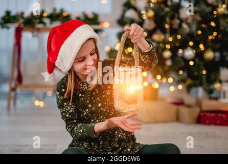 Bambina in santa cappello che tiene la candela Foto Stock