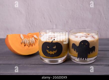 Latte di zucca in bicchieri di vetro e disegni a tema Halloween. Foto Stock