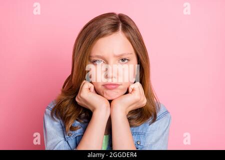 Foto ritratto ragazza cattivo umore grumpy viso infelice isolato pastello rosa sfondo colore Foto Stock