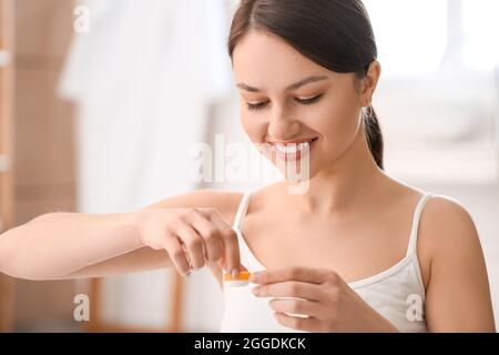 Giovane donna con lenti a contatto a casa Foto Stock