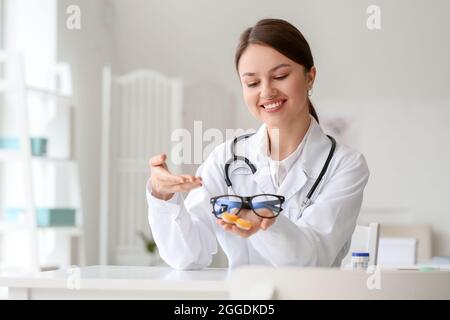 Oftalmologo con lenti a contatto e occhiali in clinica Foto Stock