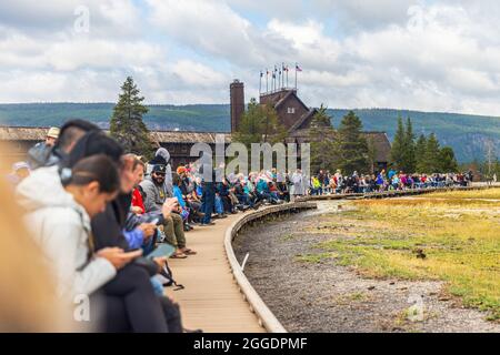 PARCO NAZIONALE DI YELLOWSTONE - 20 AGOSTO 2021: Folla di turisti che osservano l'eruzione di vecchi fedeli al Parco nazionale di Yellowstone, USA Foto Stock