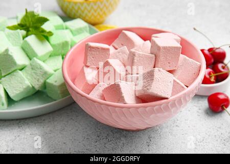 Ciotola con gustose marshmallows dolci su sfondo chiaro Foto Stock