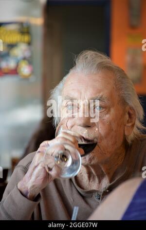 uomo di 88 anni che ha il suo mezzo bicchiere settimanale di vino rosso per pranzo con la sua unica figlia che è il suo caregiver a causa dell'età e non può guidare Foto Stock