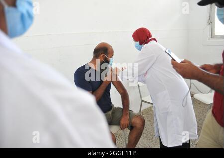 Tunisia. 29 agosto 2021. BIZERTE, TUNISIA - AGOSTO 29: Un uomo riceve una dose di Pfizer-BioNTech durante una campagna di massa per vaccinare le persone contro la malattia di Covid-19 e ridurre il rischio di infezione. Più di 460,000 persone vaccinate durante il terzo giorno nazionale di vaccinazione di massa contro il coronavirus, secondo i risultati del terzo giorno nazionale di vaccinazione di massa contro il coronavirus, 467,631 persone hanno avuto la loro prima dose di vaccino. Il 29 agosto 2021 a Bizerete, Tunisia.(Foto di Hasan Mrad/Eyepix Group) (Foto di Eyepix/Sipa USA) Credit: Sipa USA/Alamy Live News Foto Stock