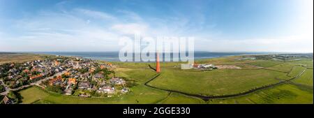 Grande colpo di drone panoramico del faro di Huisduinen, chiamato il Long Jaap con il villaggio di New Den Helder, un canale d'irrigazione in primo piano Foto Stock