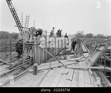 Una vista della costruzione della Birmingham a Preston autostrada (M6), che mostra il primo dei grandi travi post-tensionate che vengono cementate in situ sul Ponte 306 (Barn Bank Lane Bridge). Nell'album, la didascalia digitata sotto la fotografia recita 'calcestruzzo che viene posto al primo dei grandi fasci lunghi 95'-0", 70 tonnellate, post-tensionati sul ponte 306/ (Barn Bank Lane). Questi vengono gettati sopra le spalle e i piloni a causa delle difficoltà di movimentazione di travi di questa dimensione. Questa particolare trave è stata ora sollecitata ed è autoportante attraverso la campata". Questo ponte stradale, che si trova Foto Stock