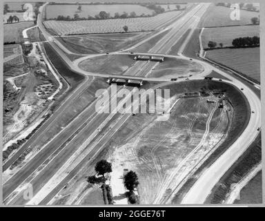 Una vista aerea che guarda verso nord verso lo svincolo 16 sulla M1, lo svincolo A45 che porta la Weedon-Northampton Road sopra l'autostrada, preso durante la sua costruzione. La didascalia sotto la stampa dell'album si riferisce a questa immagine come alla "London/Birmingham Motorway". Data la posizione, possiamo presumere che questa sia l'autostrada M1, che era anche conosciuta come l'autostrada da Londra a Yorkshire. Foto Stock