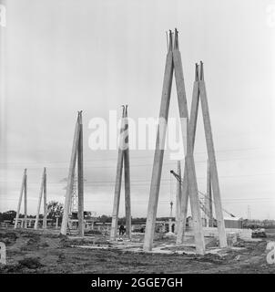 Una vista di cavi in cemento e supporti per quadri elettrici eretti nella sottostazione elettrica di Harker durante la costruzione. La costruzione di una nuova sottostazione a Harker per l'autorità Centrale elettrica è iniziata nel gennaio 1957. Al centro del sito è stato creato un cantiere di colata per la produzione di oltre 650 unità in cemento armato di varie dimensioni, pesi e disegni per il progetto. La newsletter di Laing, "Team Spirit", ha descritto la visione della costruzione del sito come "un moderno, immutificato Stonehenge". Foto Stock