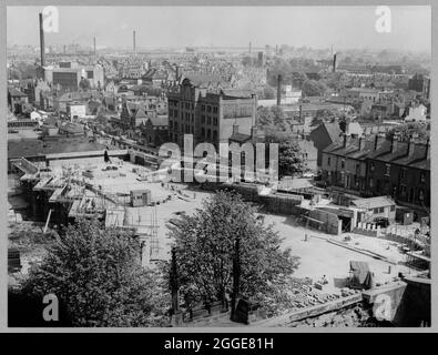 Una vista dalla torre della vecchia cattedrale di Coventry sul sito di costruzione della nuova cattedrale, guardando verso nord-est attraverso la città verso fabbriche e camini. Questa immagine è stata catalogata come parte del Breaking New Ground Project in collaborazione con il John Laing Charitable Trust nel 2019-20. Foto Stock