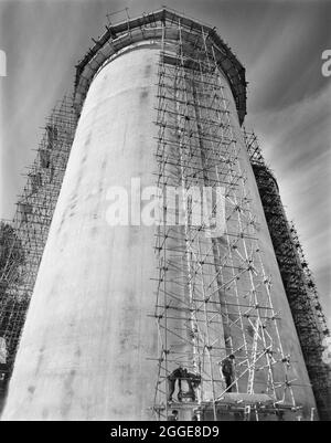 Guardando dalla base di un silo di zucchero di recente costruzione presso la fabbrica di barbabietole da zucchero Allscott, che mostra una torre ponteggi eretta per effettuare post-tensionamento di cavi di stress che corrono intorno al silo. Una fabbrica di barbabietole da zucchero si trovava ad Allscott dal 1927 fino alla sua chiusura nel 2007. Laing costruì qui due silos di zucchero nel 1961 per la British Sugar Corporation che era proprietaria del sito. Ogni silo era in grado di immagazzinare 10,000 tonnellate di zucchero granulato e al momento della loro costruzione, erano le più alte che Laing aveva costruito finora utilizzando casseforme scorrevoli. I cavi in tensione sono stati post-tensionati wi Foto Stock