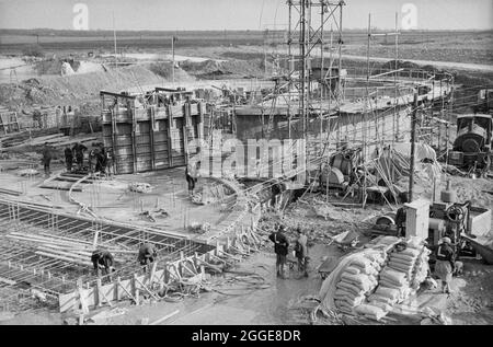 Una vista sul sito di costruzione di due silos di zucchero presso la Bardney Sugar Factory, che mostra ai lavoratori del Laing che svolgono vari compiti. Laing costruì due silos di zucchero per la British Sugar Corporation Limited presso la Bardney Sugar Factory. I silos prestressati di calcestruzzo post-tensionato sono stati realizzati con casseri scorrevoli utilizzando martinetti idraulici da arrampicata. Foto Stock