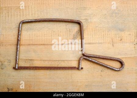 telaio e lama per seghetto arrugginito su tavola in legno intemperato, norfolk, inghilterra Foto Stock