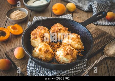 Gnocchi dolci con pangrattato dolce, ripieni di albicocche, su tavola di legno Foto Stock