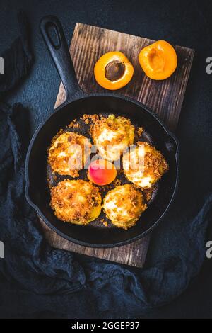 Gnocchi dolci con pangrattato dolce, ripieni di albicocche, su sfondo nero, vista dall'alto Foto Stock
