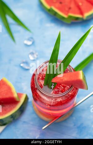Watermelon bere in vetro con fette di watermelon su sfondo di legno Foto Stock