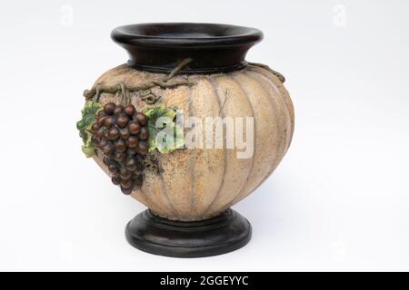 Un vaso fatto sembrare una zucca con grappoli di uva su di esso. Isolato. Fondo bianco. Foto Stock