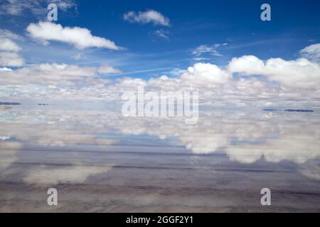 Salar de Uyuni. Salare piatto con acqua. Riflessi di un cielo perfetto. Il cielo blu e le nuvole si riflettono sull'acqua del piatto di sale Foto Stock