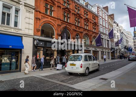 Taxi White London passando in New Bond Street, Londra, Inghilterra, Regno Unito Foto Stock