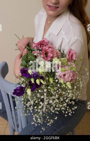 una ragazza o una donna tiene un bouquet di piccoli fiori. Foto Stock