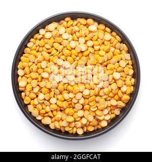 Macro primo piano di Bram Bengala biologico (Cicer arietinum) o chana dal giallo diviso su una ciotola nera in ceramica. Vista dall'alto Foto Stock