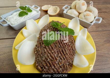 quibe crudo con cipolla affettata, cagliata secca, pita pane e foglie di menta. Foto Stock