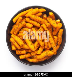 Primo piano di Chutney Sev piccante in una ciotola nera in ceramica realizzata con farina di ceci e peperoncino rosso. Mucchio di spuntini speziati indiani (Namkeen), vista dall'alto Foto Stock