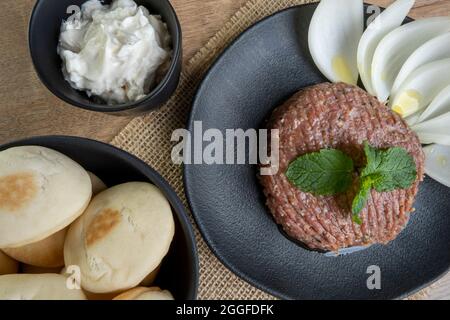 quibe crudo con cipolla affettata, cagliata secca, pita pane e foglie di menta. Foto Stock