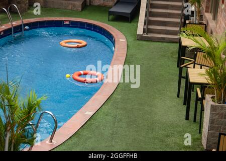 Piccola piscina in villa privata di lusso, con tavoli e sedie intorno, piante decorative Foto Stock