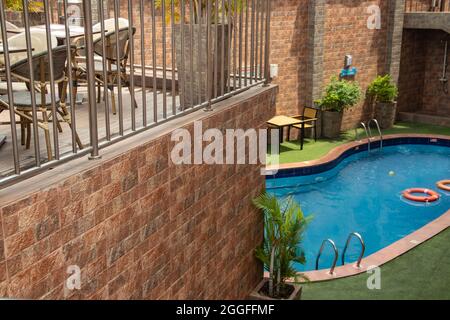 Piccola piscina in villa privata di lusso, con tavoli e sedie intorno, piante decorative Foto Stock