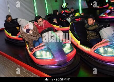 Famiglia sul terreno fieristico funfair dodgem auto giro Birmingham, Gran Bretagna, Regno Unito Foto Stock