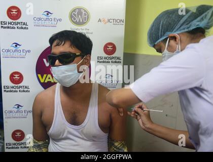 Kolkata, India. 31 ago 2021. L'uomo ipovedente viene somministrato con il vaccino della corona Covishield all'ospedale. Le persone ipovedenti vengono vaccinate contro la diffusione dell'infezione da covid-19 all'ospedale Maniktalata ESI organizzato dal Social welfare per la ONG Blind. Credit: SOPA Images Limited/Alamy Live News Foto Stock